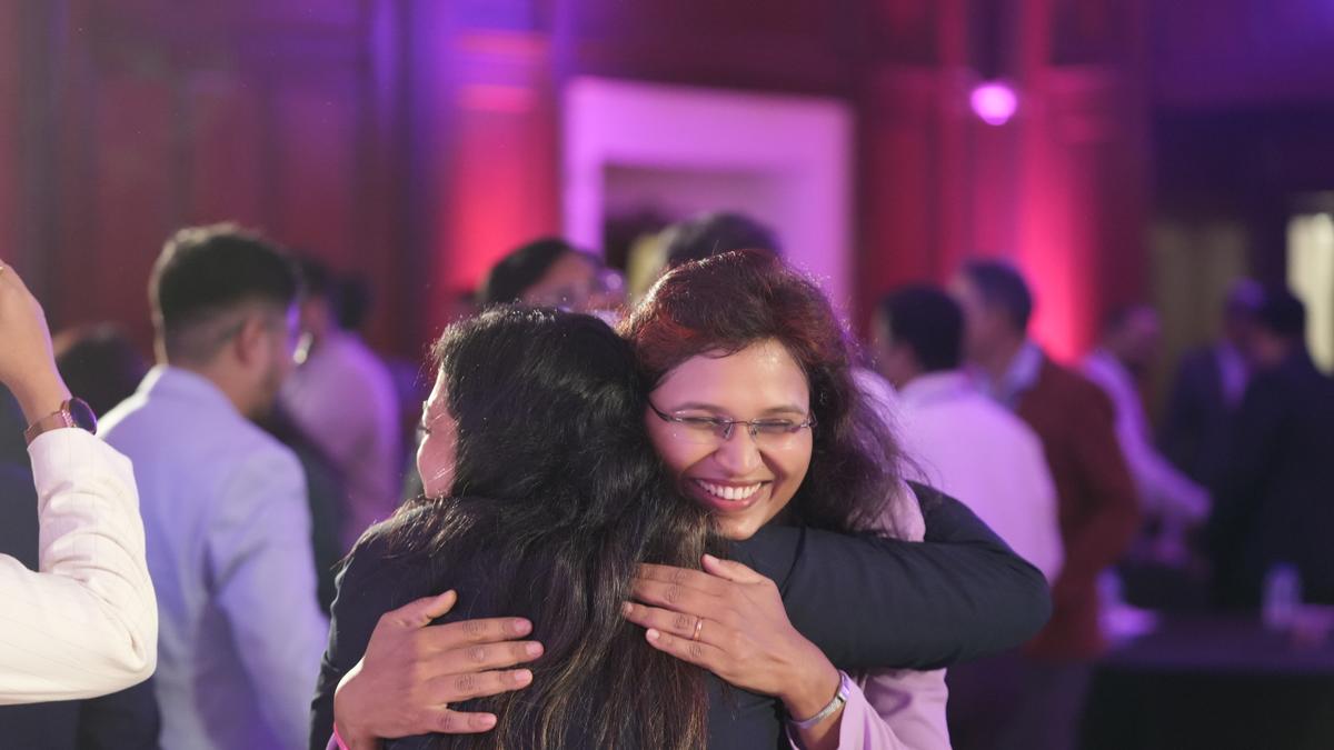 Two attendees sharing a warm hug at a Career Grooming Retreat networking event