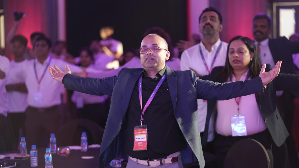Attendee with arms raised at Career Grooming Retreat closing ceremony